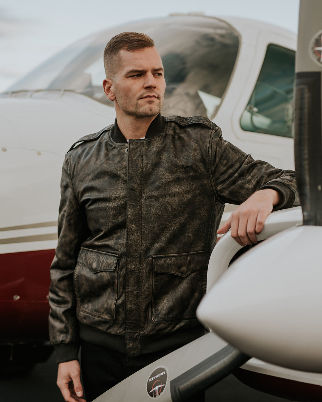 man at tarmac with bomber jacket